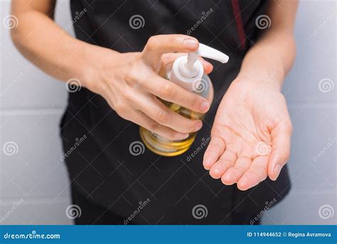 A Professional Masseur Puts Oil On His Hands Before The Procedure Stock