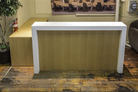 custom     shaped maple reception desk  white stone