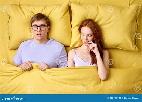 Happy Couple Lying In Bed Under Duvet After First Sex Experience Man