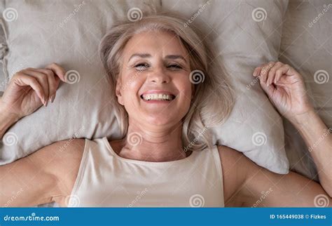 Happy Refreshed Elderly Female Lying In Bed Looking At Camera Royalty