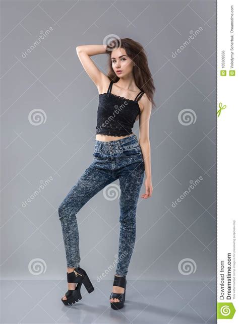 portrait of pretty woman model with beautiful long legs standing wearing denim jeans black