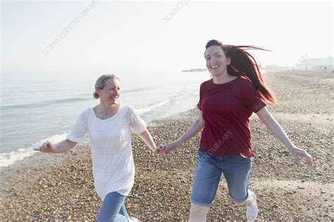 Playful Lesbian Couple Running On Beach Stock Image F023 0068
