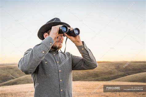 man   binoculars lifestyle rolling landscape stock