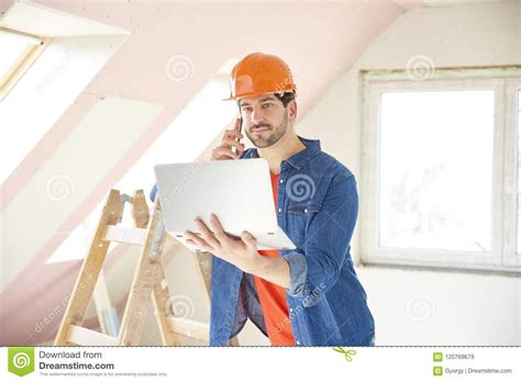 young handyman   mobile phone  construction site stock image image  holding handy