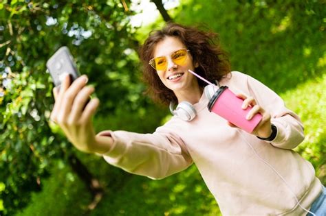 premium photo girl makes selfie on a wall of green park