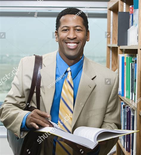 stock photo portrait   happy male professor  book  college library  ncrll