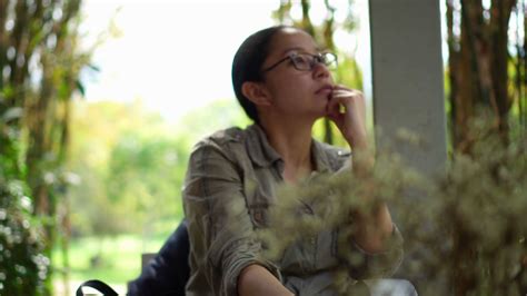 mixed race asian woman sit relax and thinking in cafe garden stock