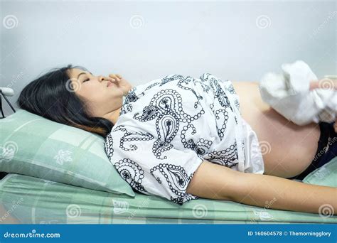 Young Asian Pregnant Woman Preparing Herself For Giving Birth In