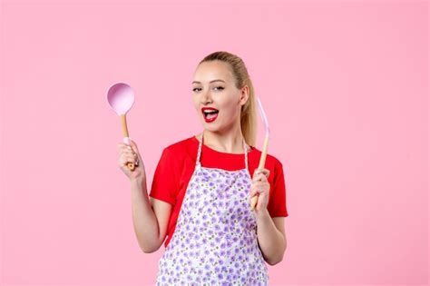 Premium Photo Front View Young Housewife Holding Cutlery On Pink Wall