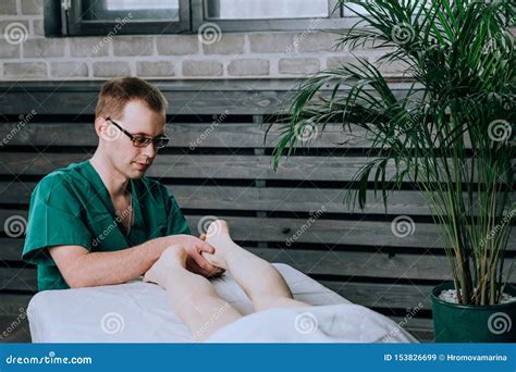 A Male Massage Therapist Massages The Feet And Legs Of Legs Stock