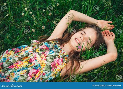 девочка подросток лежит на траве и смеется Стоковое Фото изображение