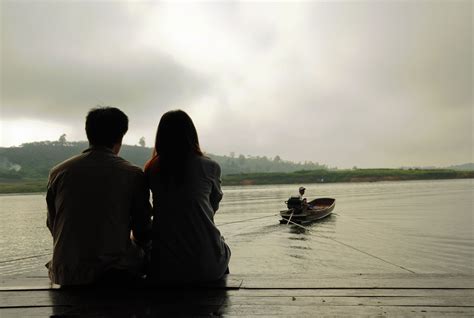 couple sitting near on river hd wallpaper wallpaper flare