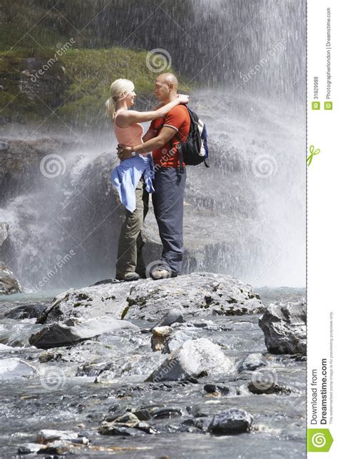 Couple Embracing Under Spray Of Waterfall Royalty Free