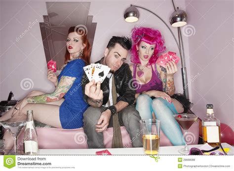 Man Showing Playing Cards Tattooed Women Sitting Besides