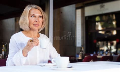 Positive Mature Woman 50s Years Old Is Lunching With Coffee In Cafe