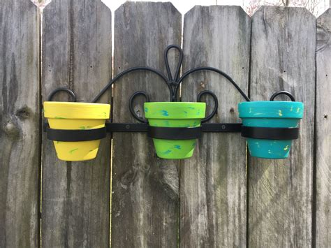high gloss enamel painted wrought iron  painted terra cotta pots  outdoor fence decor