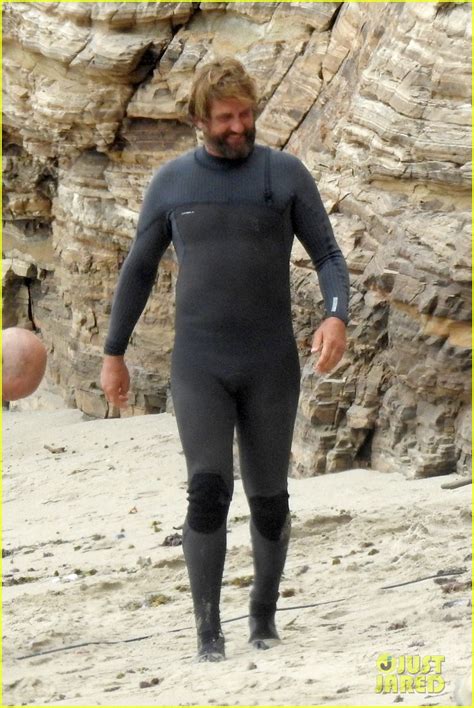 gerard butler puts on his skintight wetsuit for a day of surfing photo