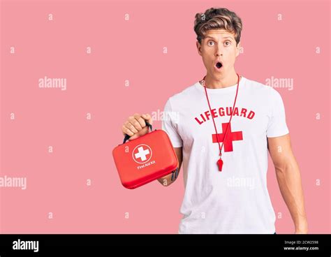 young handsome man wearing lifeguard  shirt holding  aid kit