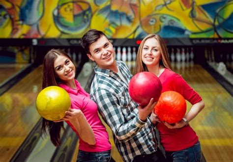 Premium Photo Cheerful Friends At The Bowling Alley With The Balls