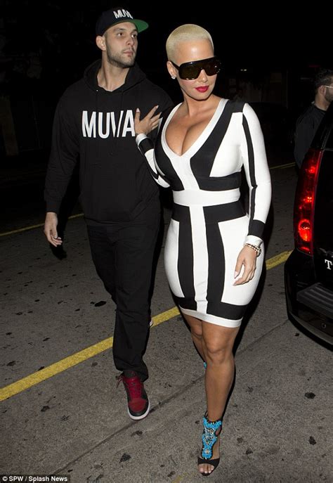 amber rose accentuates her curves in a figure hugging patterned dress