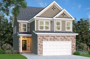 multiple stone feature elements surround  front loading  car garage  front entra