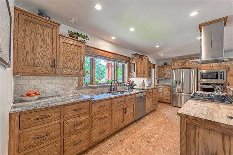 large kitchen  wooden cabinets  stainless steel appliances   marble counter tops
