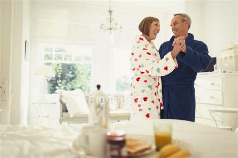 Mature Couple Dancing In Bathrobes In Bedroom — Breakfast Woman