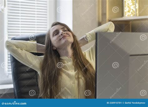 Happy Young Woman Sits With Closed Eyes And Clasped Her Hands Behind