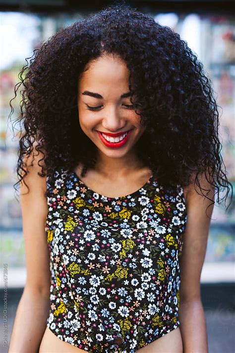 Portrait Of A Young Latin Afro Woman With Red Lips Laughing Outside By