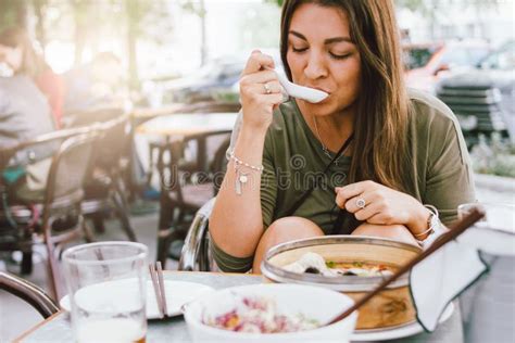 young smiling brunette girl eating dim sum  asian street cafe stock