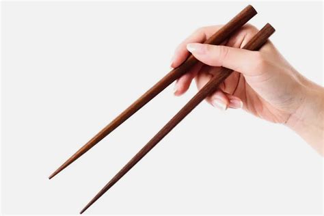 proper   hold chopsticks sushi roll   black plate  woman hand holding chopsticks