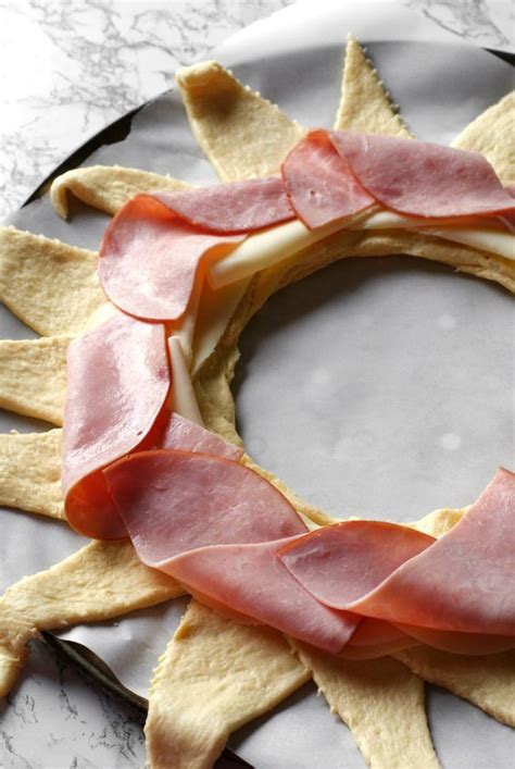an italian sub crescent roll ring is packed full of ham