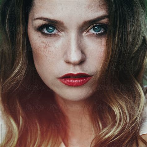 Artistic Portrait Of A Beautiful Young Woman With Freckles And Blue