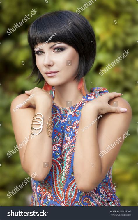 beautiful brunette woman wearing bright dress posing in