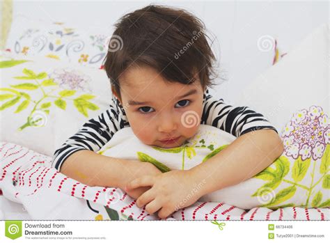 Little Brunette Girl Lying On Her Stomach In The Bed Stock