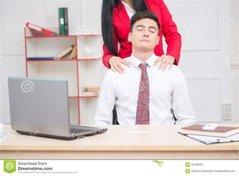 woman doing massage to her colleague in office stock