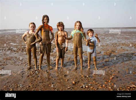 kinder die im schlamm auf felsigen strand bedeckt stockfotografie alamy