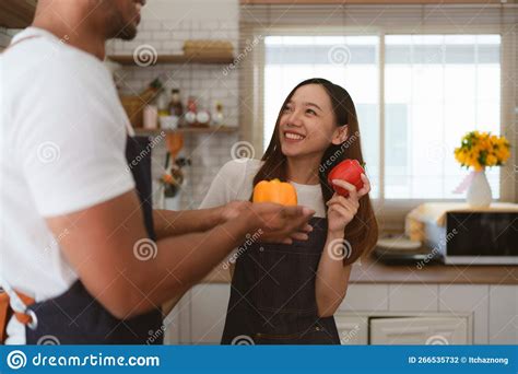 Portrait Of Young Asian Couple Making Salad Together At Home Cooking