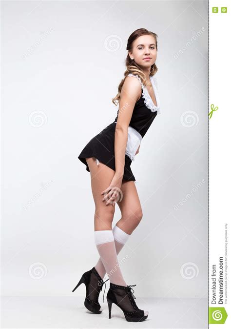 bella giovane donna vestita come domestica servo sexy in un uniforme succinta posante