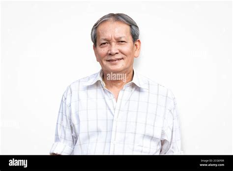 Portrait Of Smiling Asian Senior Man Standing In Front Of White