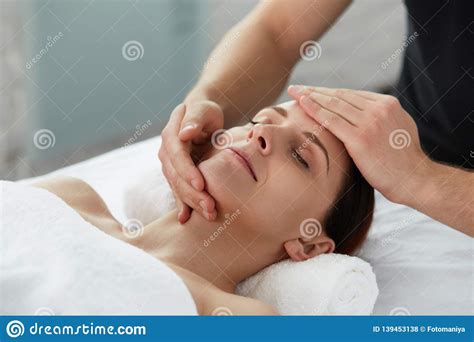 professional massage therapist is treating a female patient in