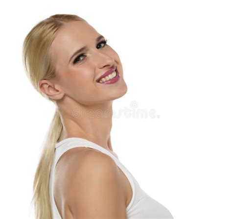 Side View Of A Young Smiling Blond Woman With Tied Hair And Makeup