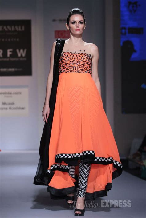 a model showcases a strapless tangerine kurta with monochrome churridar pants fashion style