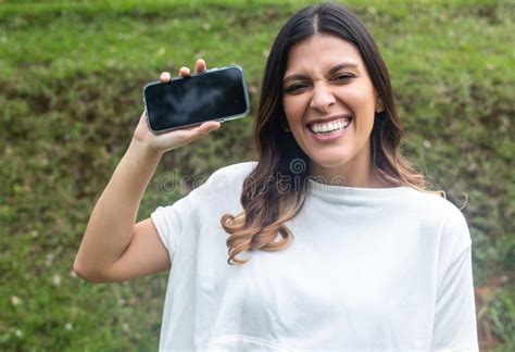 A Young Girl Latina Woman Is Holding A Smartphone Horizontally In Front