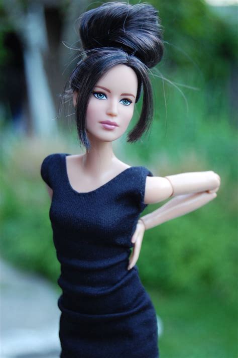 A Doll With Black Hair And Blue Eyes Is Posed On A Sidewalk In A Dress