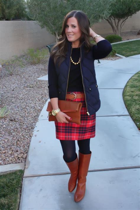 red and navy plaid skirt navy sweater navy quilted vest cognac boots belt fashion