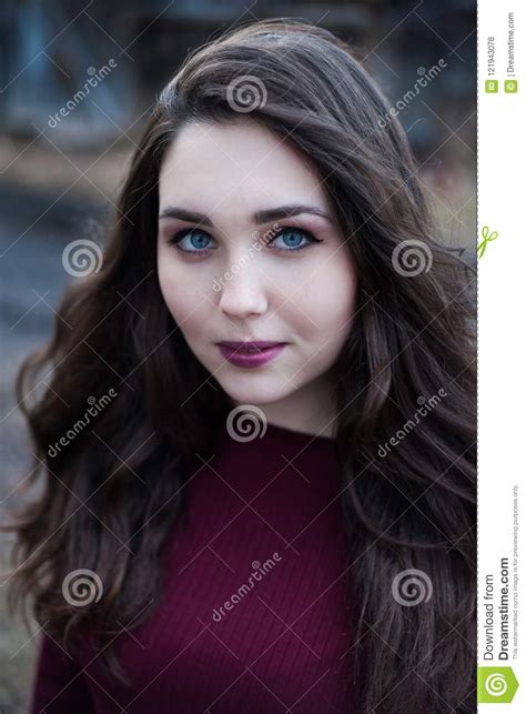 Portrait Of A Blue Eyed Girl With Dark Hair In Cherry