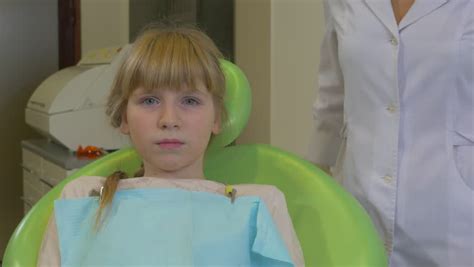 teenage girl patient in a chair dentist puts a plastic
