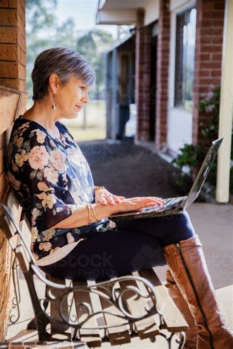Image Of Mature Woman Sitting On Park Bench Chair Outside
