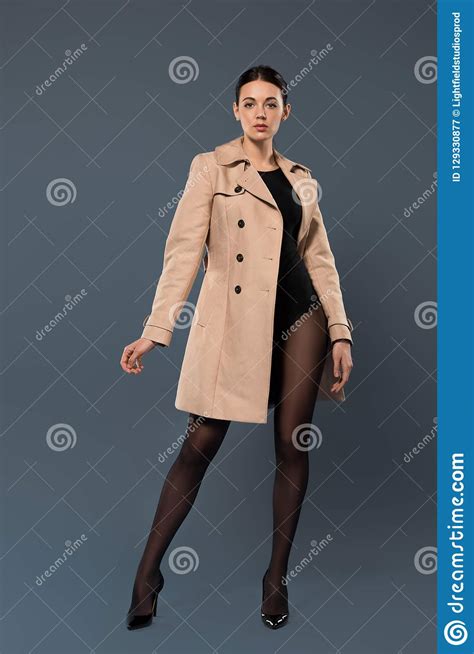 woman in black pantyhose and heel shoes wearing trench